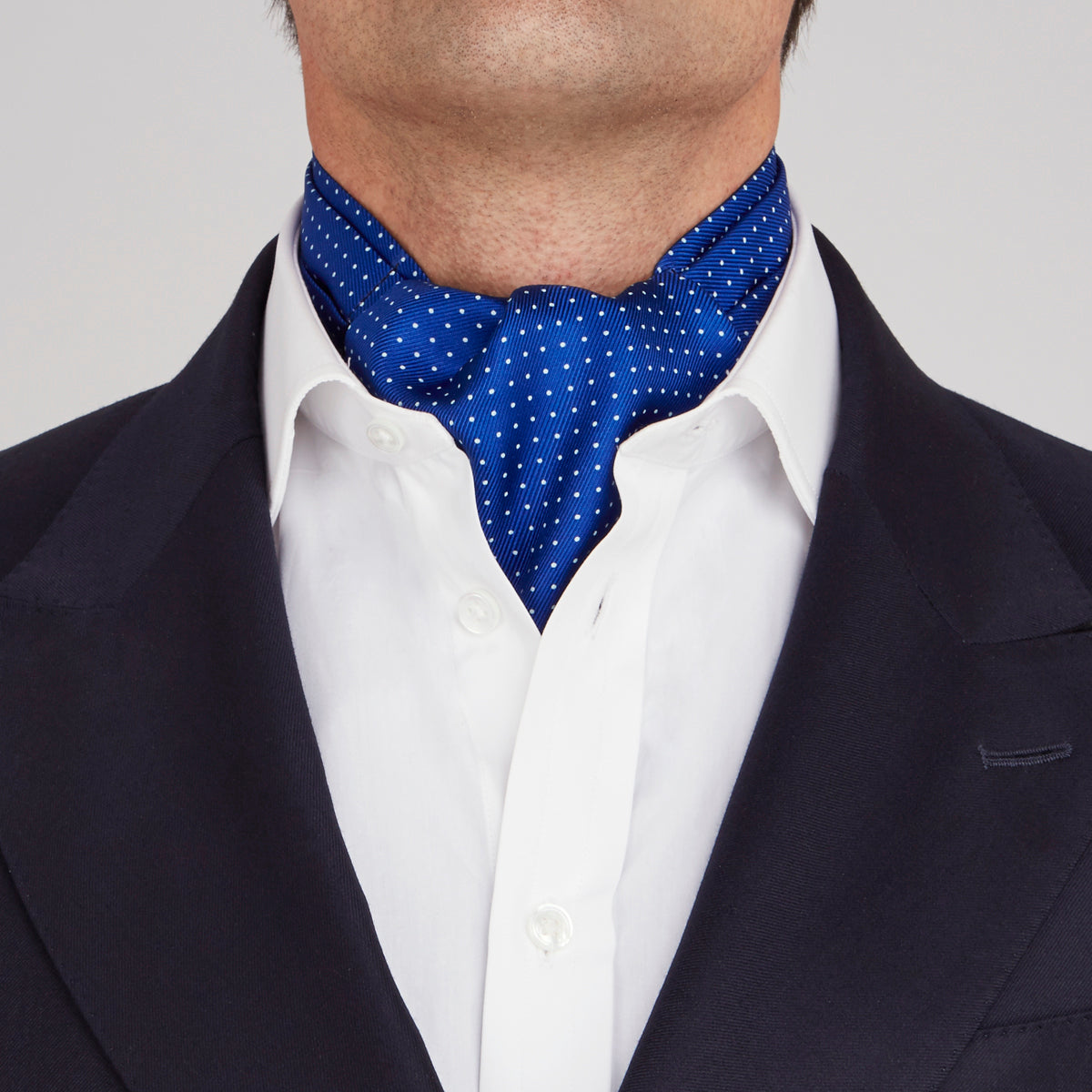 View 2 of product The Turnbull & Asser Royal Blue and White Small Spot Silk Ascot Tie, featuring fine white dots on blue silk, is shown on a plain white background—an elegant finishing touch for any wedding guest outfit.