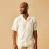 View 2 of product The Turnbull & Asser Cream Holiday Fit Silk Phillips Shirt features a revere collar, short sleeves, and three front pockets, shown flat on a white background.