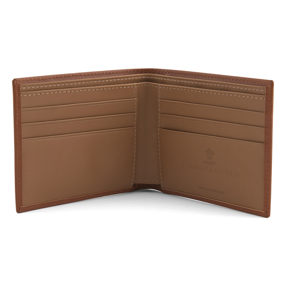 A closed Light Tan Leather Billfold by Turnbull & Asser stands upright against a plain white background, showcasing visible edge stitching and a smooth, minimalist design.